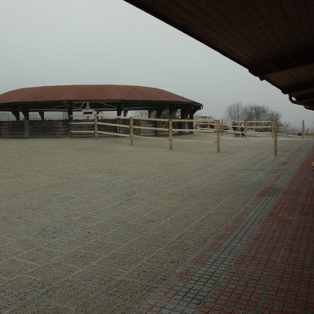 Udendørs overdækket område med træhegn og flisebelægning